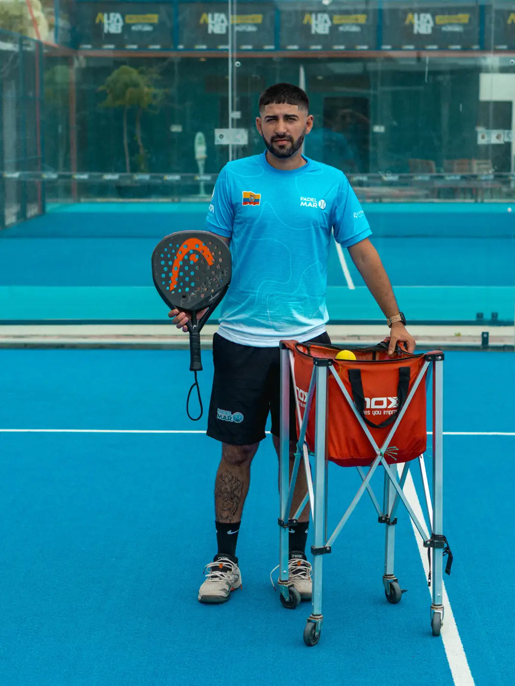 Ivo Bustos, Head Coach de la academia, con su paleta y el canasto de pelotas en la cancha