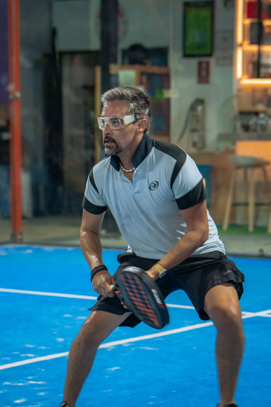Jugador con gafas protectoras en posición de espera en la cancha
