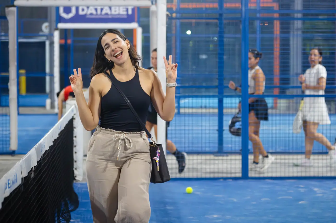 Jugadora sonriendo y haciendo la señal de la victoria en la cancha